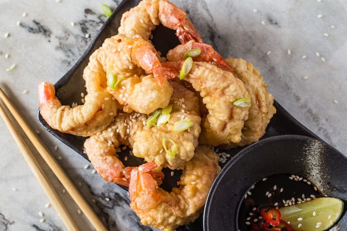 Red Shrimp Tempura with Spicy Soy Dipping Sauce on a serving dish with chopsticks on a marble board