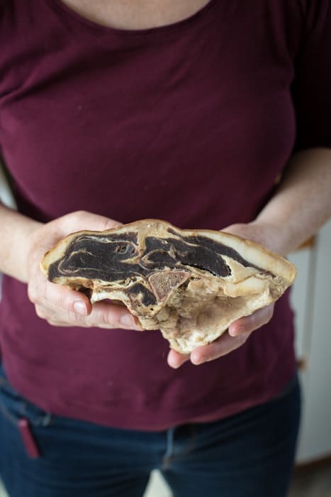 Holding a piece of dried reestit mutton waiting to be soaked then cooked in Traditional Shetland Reestit Mutton Stew