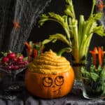 Cute smiling Halloween pumpkin with colourful vegetable crudites and pumpkin dip 'brains'!