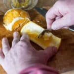 Scraping the pith from an orange to make Candied Orange Peel