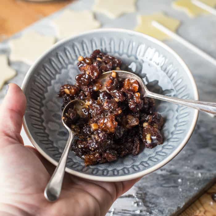 hand holding a bowl of mincemeat to make Mince Pie Pops