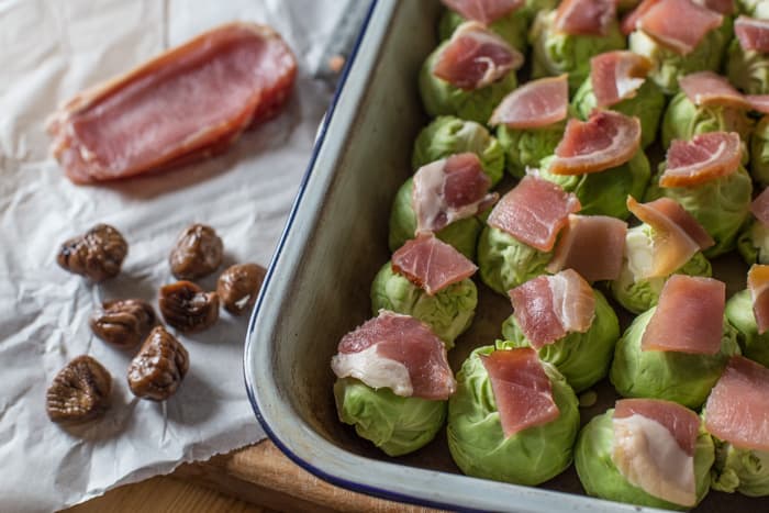 smashed Roast Sprouts with Bacon and Chestnuts in a roasting dish ready to cook