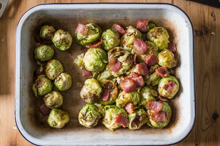 Smashing roast sprouts with bacon and chestnuts in a raosting tin