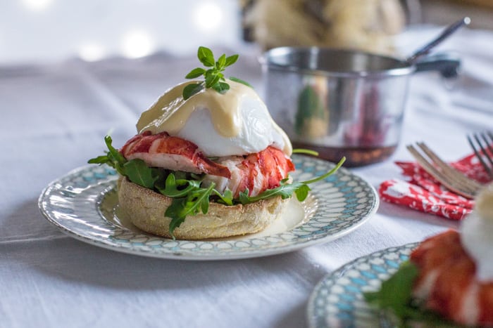 Lobster Eggs Benedict on china plates with christmas decorations