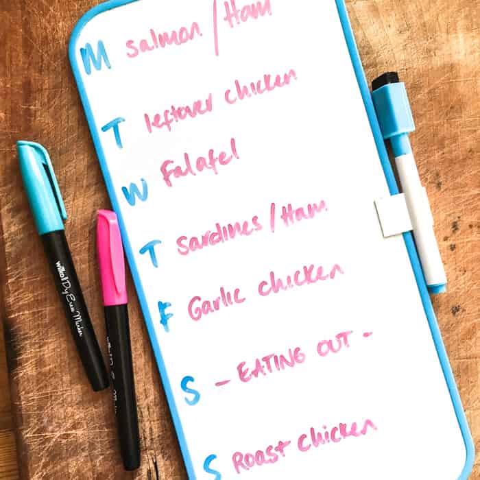 A small magnetic whiteboard that sticks to the fridge with days of the week and meal plans for each day