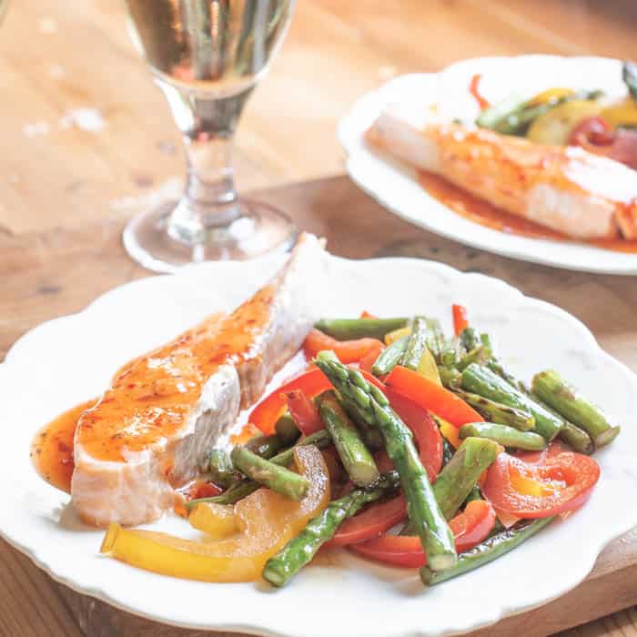 White plate with salmon fillet and asparagus stir fry