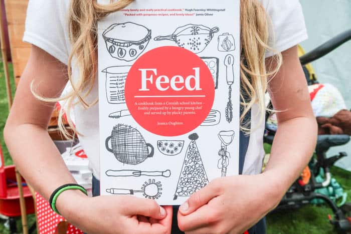 Young girl holding a book called Feed