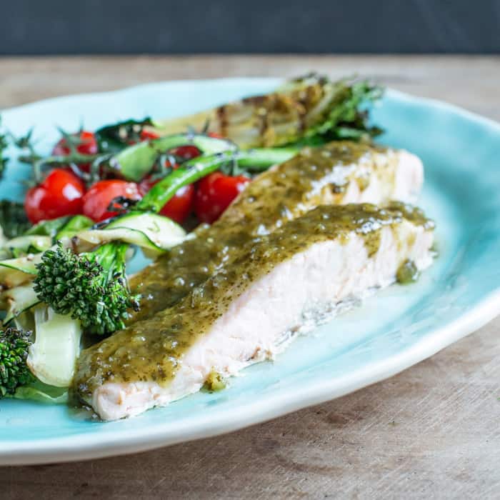 turquoise plate with grilled lettuce, cherry tomatoes, broccoli and 2 pieces of steamed salmon with green dressing