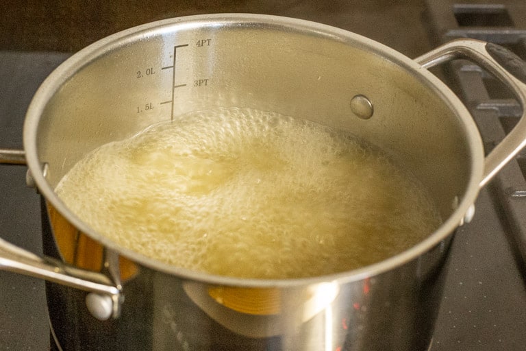 saucepan with chicken stock boiling inside