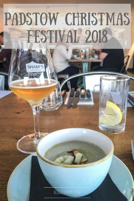 busy restaurant scene at the Padstow christmas festival with white bowl of green soup, glass of beer and glass of lemon water