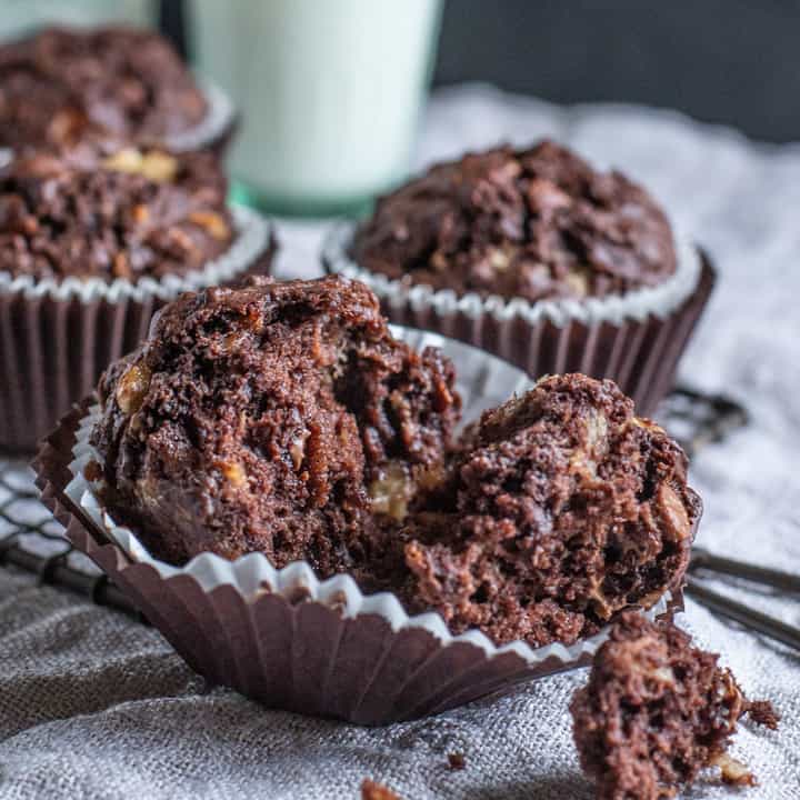Close up of banana chocolate muffin pulled apart showing a moist, chocolatey centre