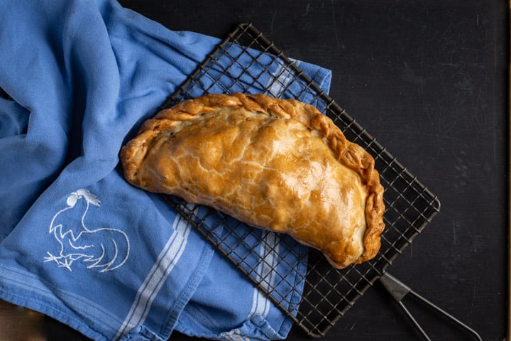 black background with blue cloth and golden Cornish pasty