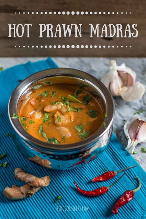 Prawn Madras Curry in a silver bowl sprinkled with coriander surrounded by fresh spices