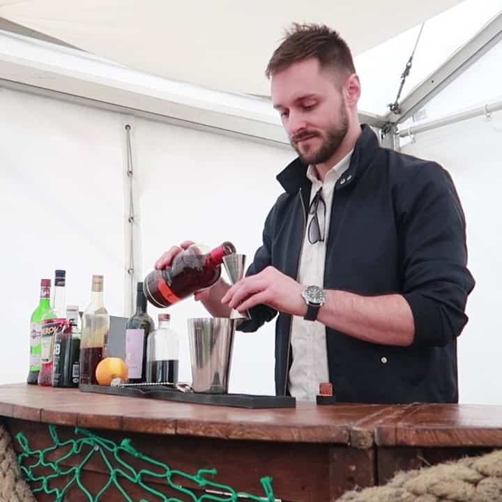 Bar tender pouring spirits into a cocktail shaker at the Porthleven Food Festival 2019