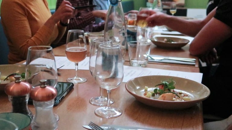 long table with several people eating and drinking beer at the Porthleven Food Festival 2019