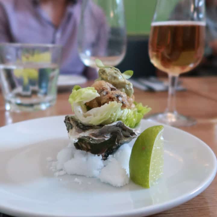 tempura oyster in a baby gem leaf, sat inside an oyster shell, balanced on a pile of salt at the Porthleven Food Festival 2019