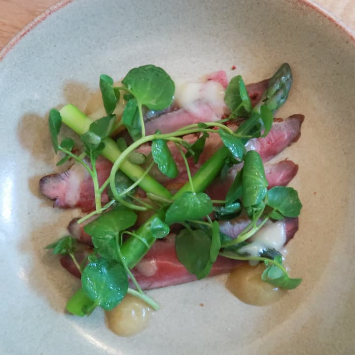 white plate with rare beef, asparagus, pea shoots and miso at the Porthleven Food Festival 2019