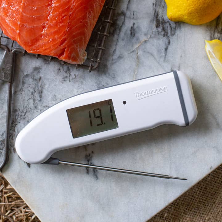 Thermapen Professional thermometer on marble chopping board with salmon