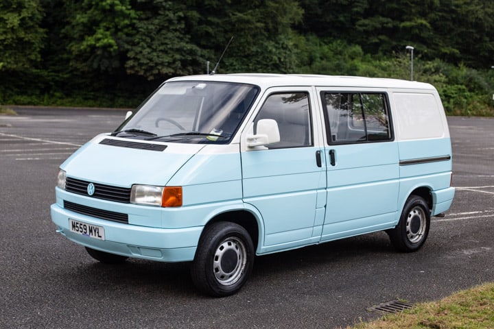 side shot of a pale blue and white VW T4 campervan parked in a car park