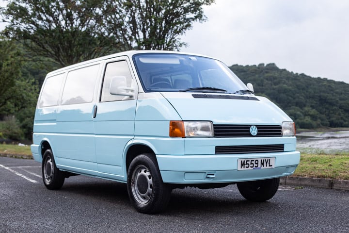 side shot of a pale blue and white VW T4 campervan parked in a car park