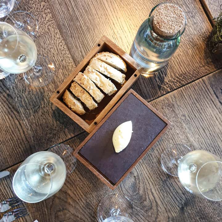 wooden table with box of homemade laverbread bread and whipped butter in wooden box