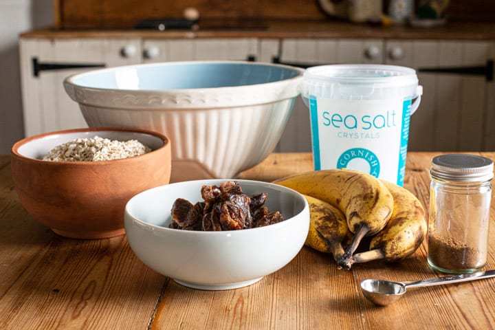 a rustic kitchen counter with verious bowls of baking supplies ready to make healthy flapjacks