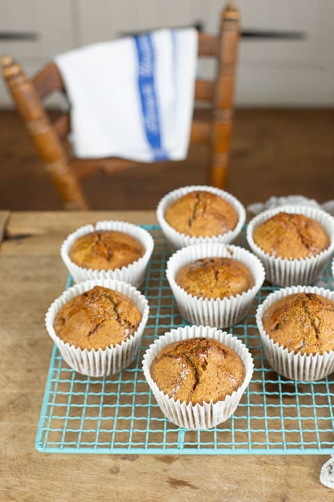 Muffins on a cooling tray on a table with chair behind them