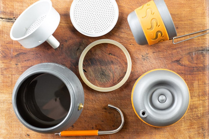 wooden background with various parts of the Chub coffee make laid out