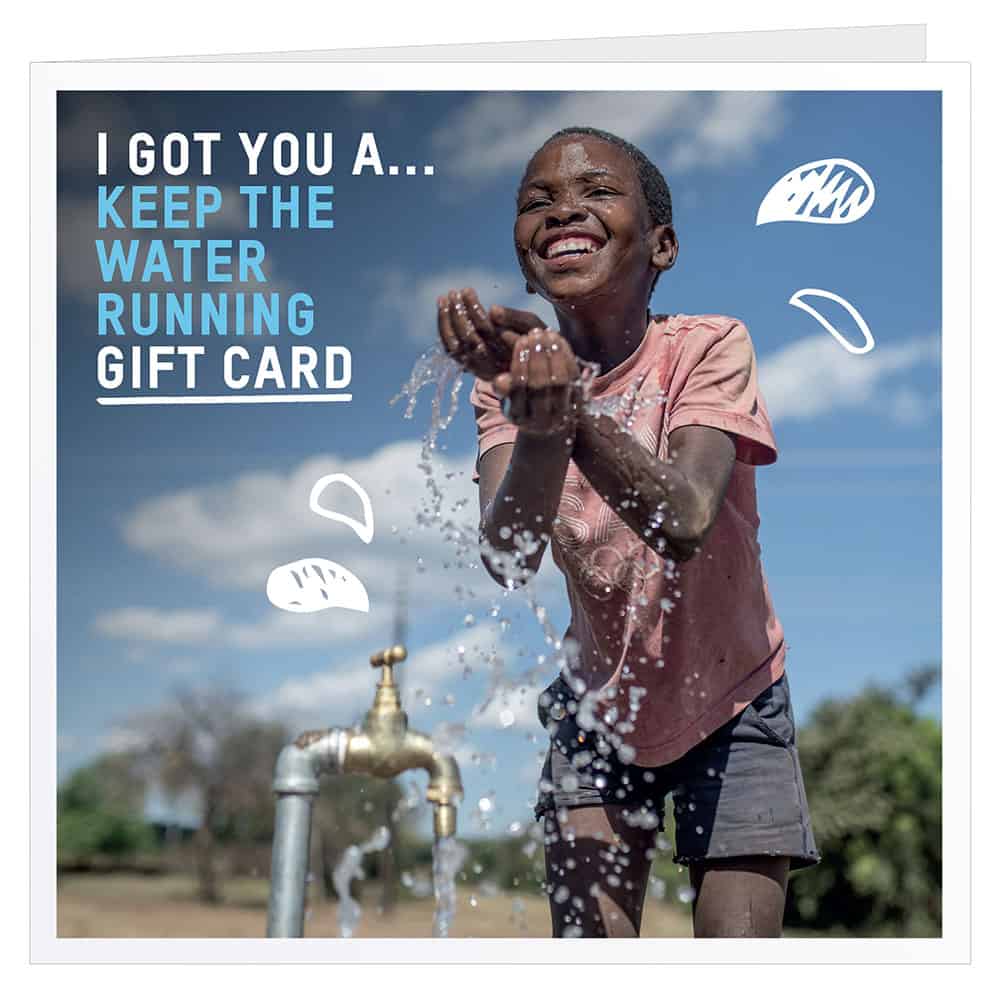 Oxfam gift card showing picture of happy boy playing with water at a charity tap