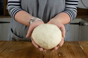 Person holding dough made with ingredients for slow cooker bread recipe