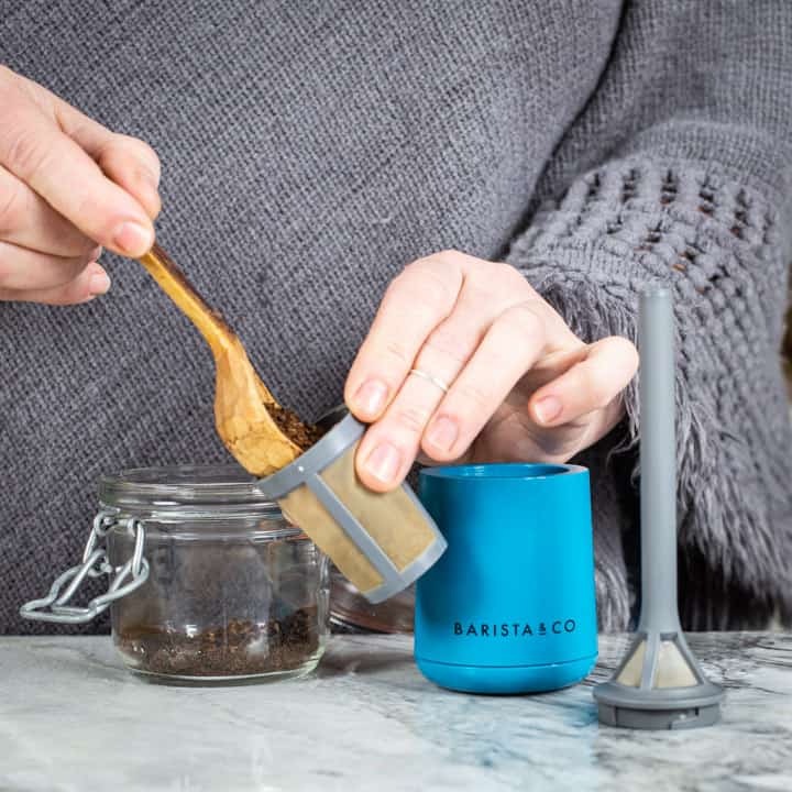 womans hands filling ground coffee into a brew it stick off grid coffee maker