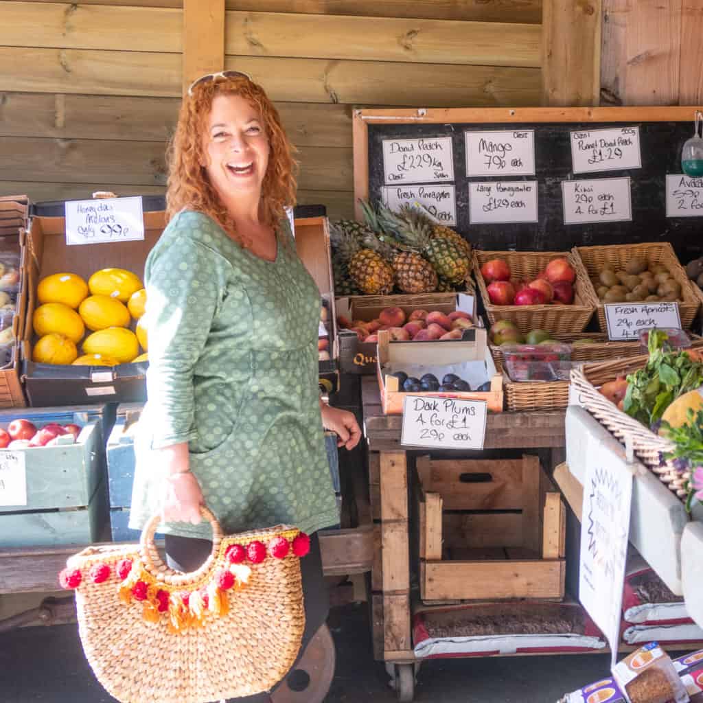 Laughing TV presenter stood in a farm shop 