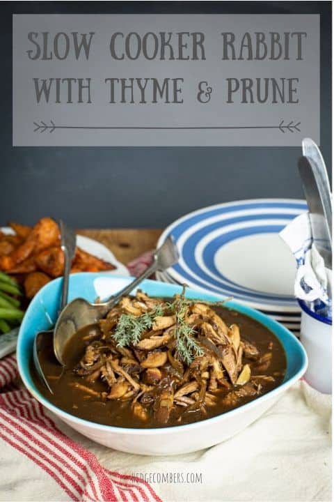 blue bowl with slow cooker rabbit and several bowls and plates showing a dinner scene