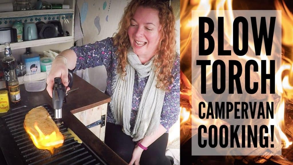 Woman using blow torch to cook. Next to it are words 'Blow Torch Campervan Cooking' and a flame behind them.