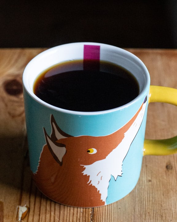 cute fox cup full of fresh black coffee