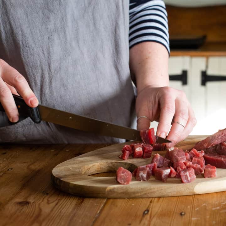 womans hnds dicing beef skirt meat to make a pasty