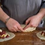 Womans hands crimping the crust of a traditional Cornish pasty