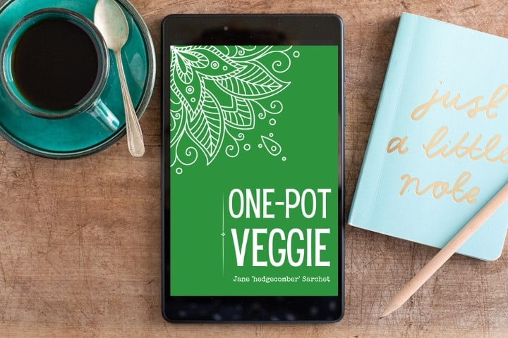 Wooden table with black iPad showing the green front cover of a digital cookbook called One Pot Veggie
