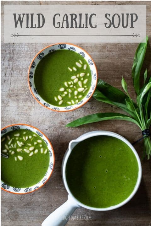 wooden background with 2 small white bowls and a whit epan filled with bright green wild garlic soup