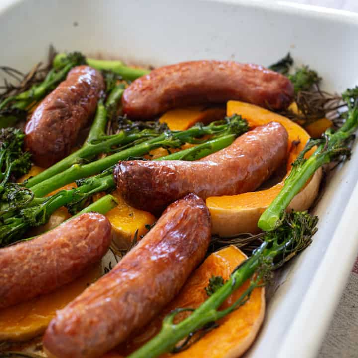 cooked sausages on slices of squash with broccolini and rosemary sprigs