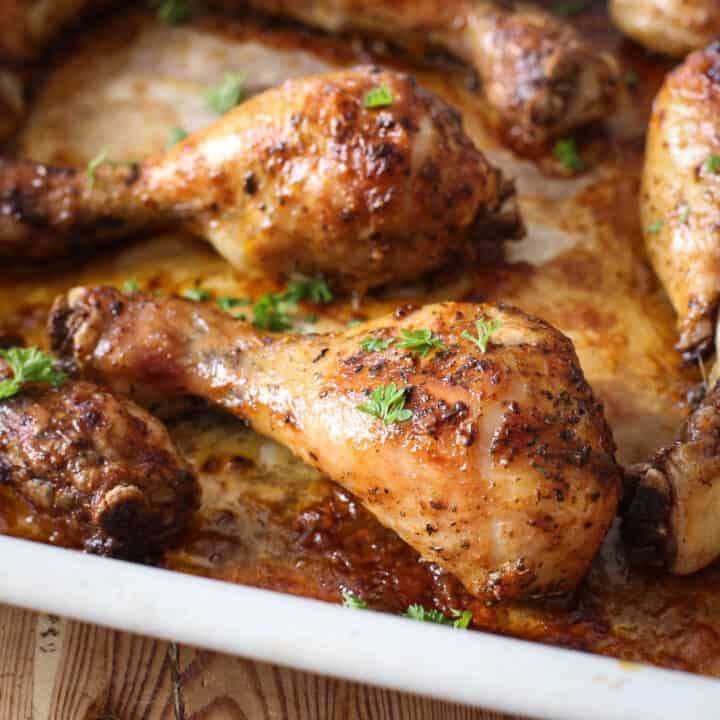 Crispy baked chicken drumsticks in a white pan hot form the oven