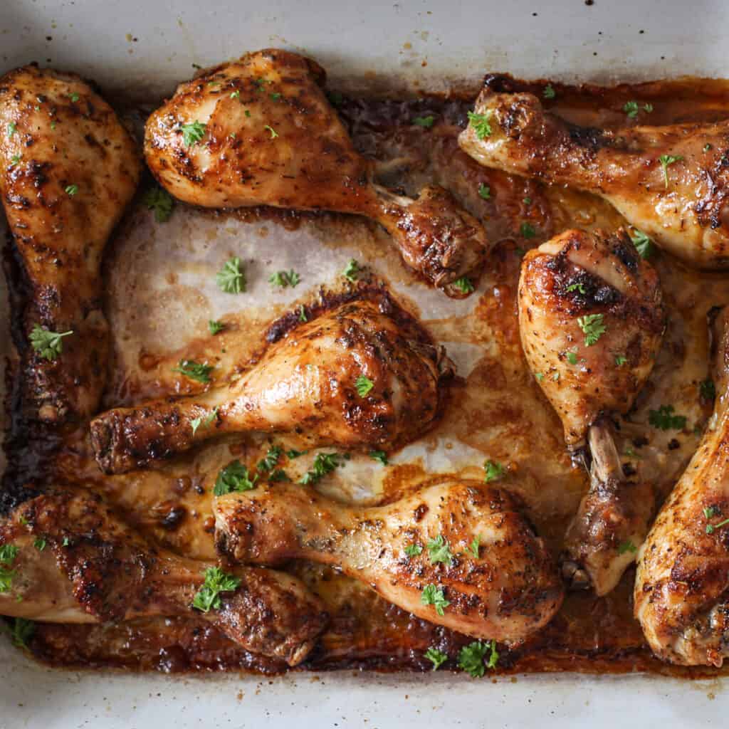 Crispy baked chicken drumsticks in a white pan hot from the oven