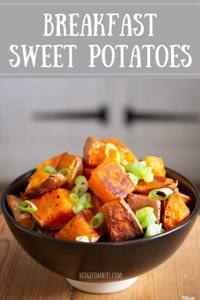 Black bowl of baked sweet potato chunks on a wooden kitchen counter
