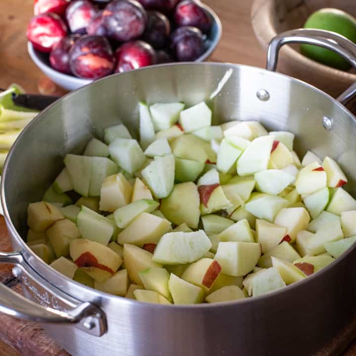 Inside a large silver saucepan half filled with chopped apples