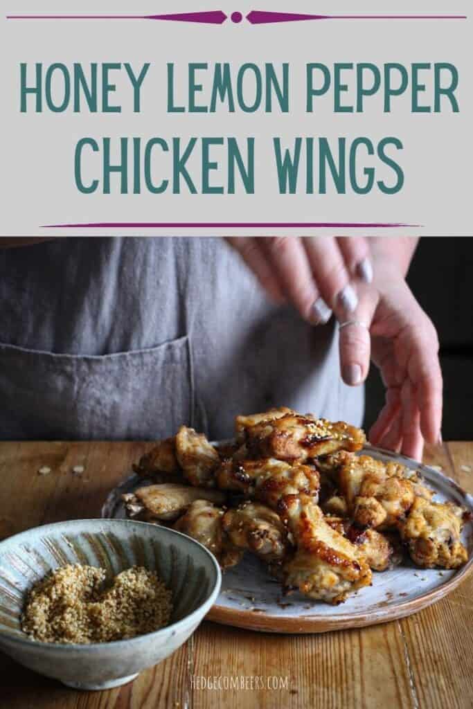 Woman sprinkling toasted sesame seeds over a white plate of honey lemon pepper chicken wings