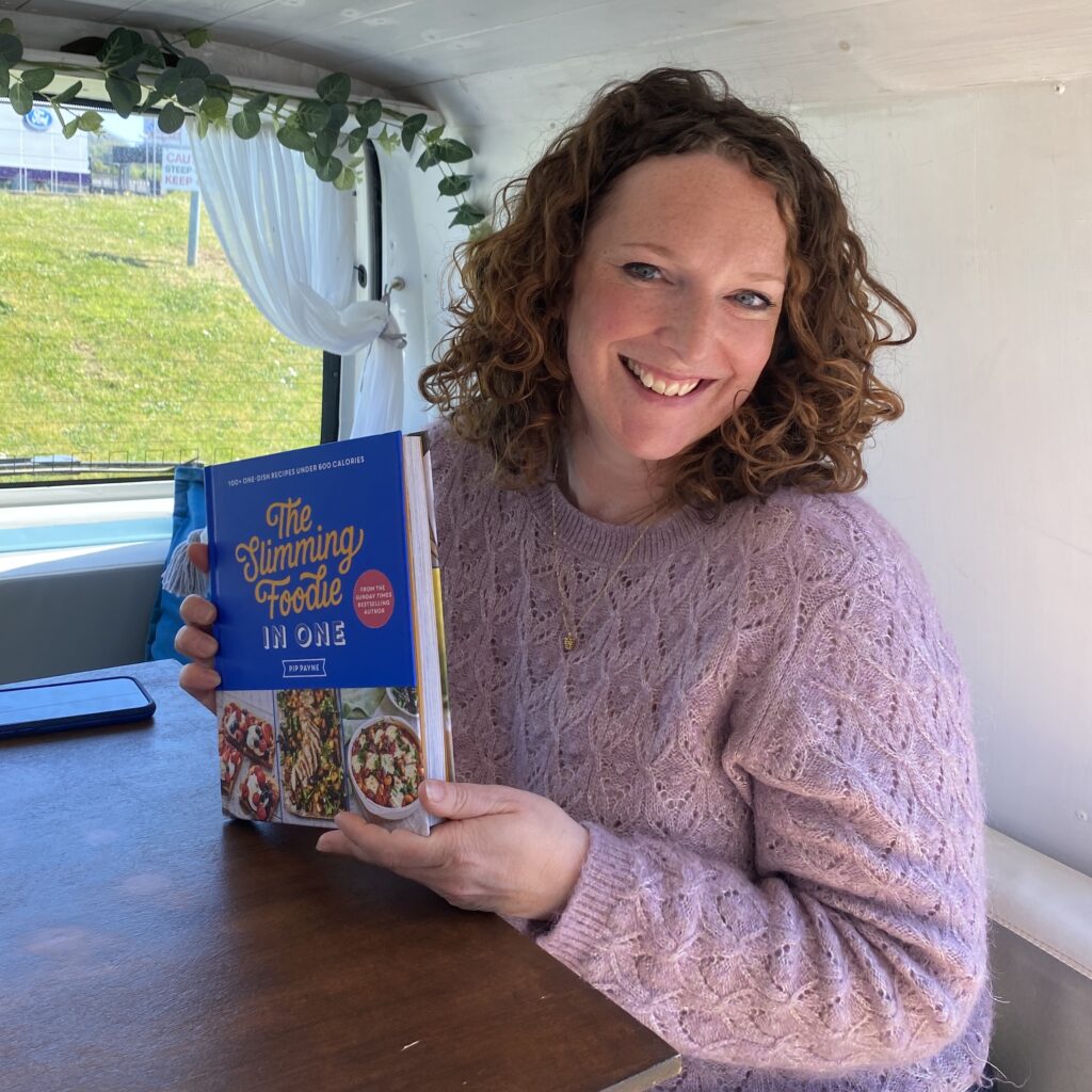 Cookbook author Pip Payne holding her second book The Slimming Foodie in One