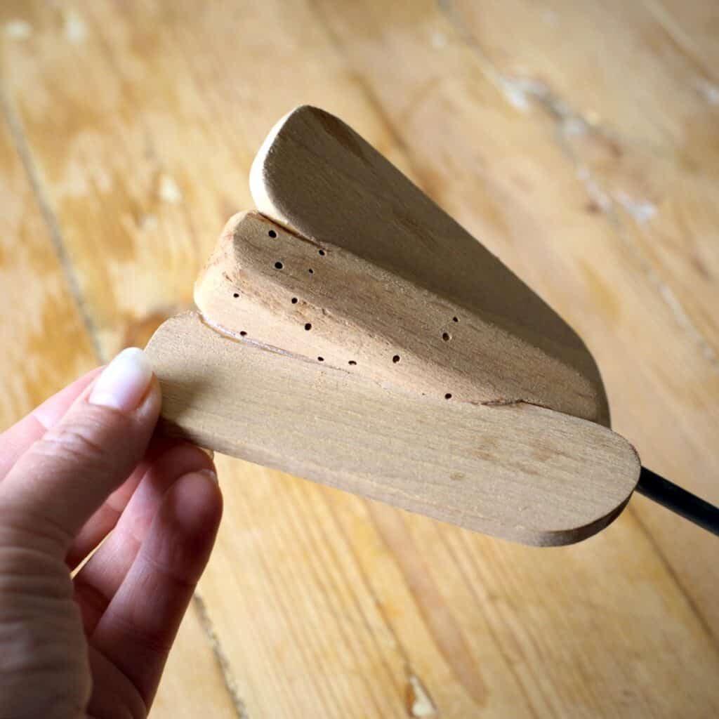 Wooden paddle from an old fashioned glass butter churn that is riddled with woodworm holes