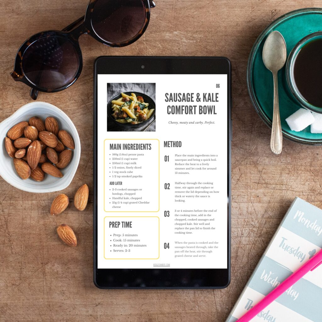 Wooden table with small bowl of almonds, sunglasses and coffee cup along with an ipad showing a pasta ebook recipe