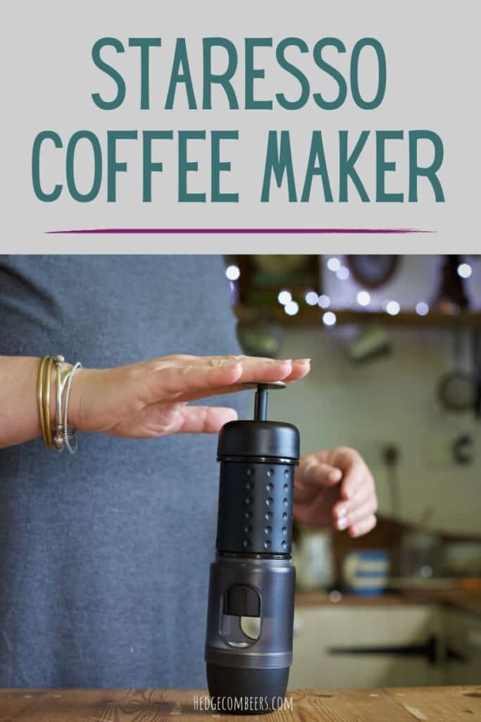 Woman in grey plunging a Staresso coffee maker in a rustic wooden kitchen